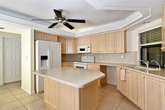 kitchen featuring a kitchen island, ceiling fan, ornamental molding, white appliances, and a tray ceiling