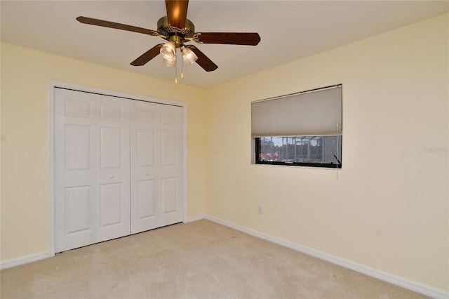 unfurnished bedroom with a closet, light carpet, and ceiling fan