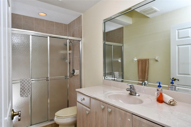 bathroom featuring an enclosed shower, toilet, and vanity