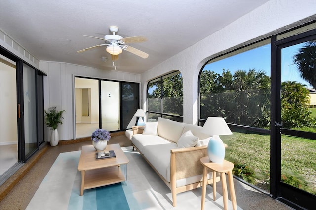 sunroom / solarium featuring a healthy amount of sunlight and ceiling fan