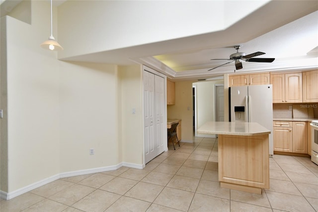 kitchen featuring light tile flooring, hanging light fixtures, a raised ceiling, and ceiling fan