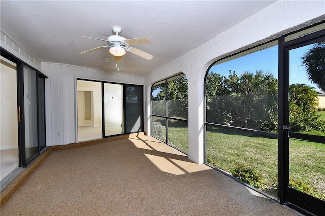 unfurnished sunroom with plenty of natural light and ceiling fan