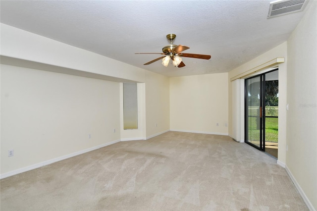 carpeted spare room with ceiling fan and a textured ceiling