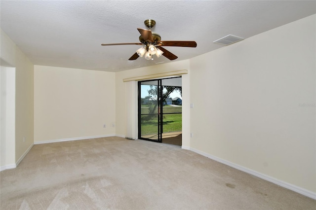 carpeted spare room with a textured ceiling and ceiling fan