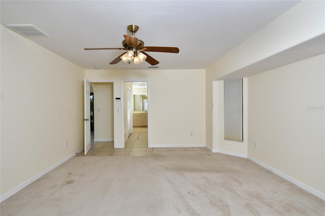 unfurnished bedroom with light colored carpet, connected bathroom, and ceiling fan