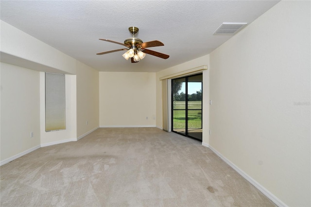 carpeted empty room with ceiling fan and a textured ceiling