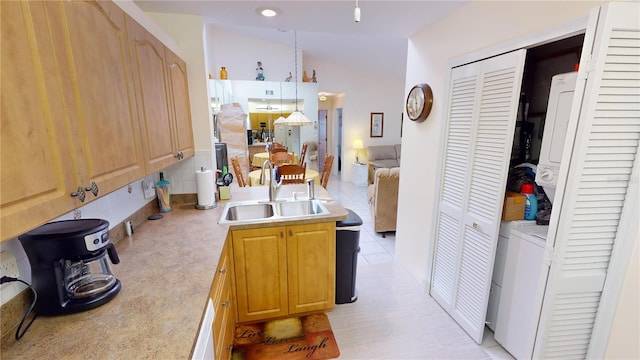 kitchen featuring light tile floors, stacked washer and dryer, lofted ceiling, backsplash, and sink