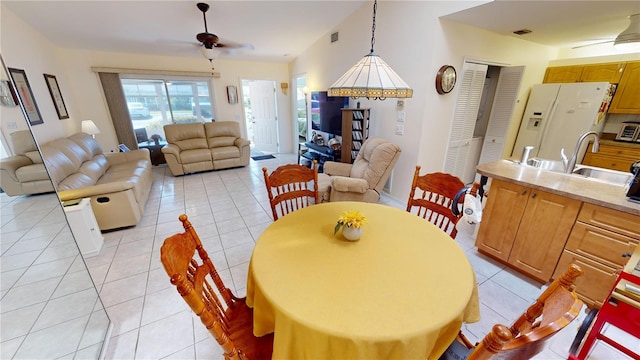 dining room featuring ceiling fan, light tile floors, and sink