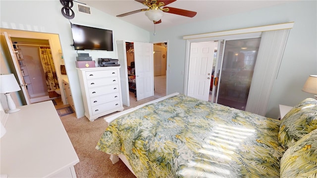 bedroom featuring light carpet, connected bathroom, lofted ceiling, and ceiling fan