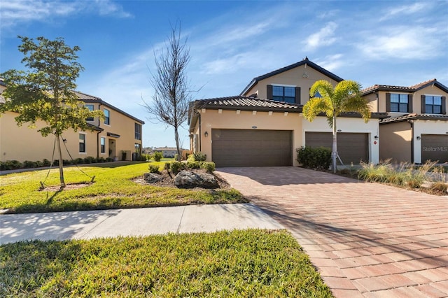 mediterranean / spanish house featuring a front lawn and a garage