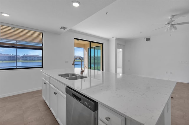 kitchen featuring a kitchen island with sink, sink, dishwasher, and a water view