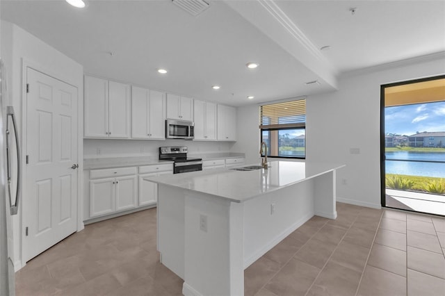 kitchen with a water view, white cabinetry, appliances with stainless steel finishes, and a center island with sink