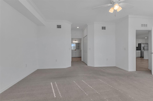 empty room featuring crown molding, light carpet, and ceiling fan