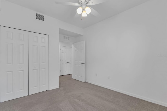 unfurnished bedroom featuring light colored carpet, ceiling fan, and a closet