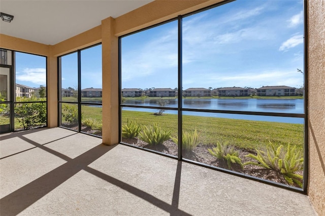 unfurnished sunroom featuring a water view