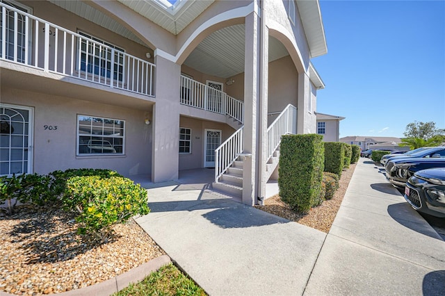 view of exterior entry with a balcony