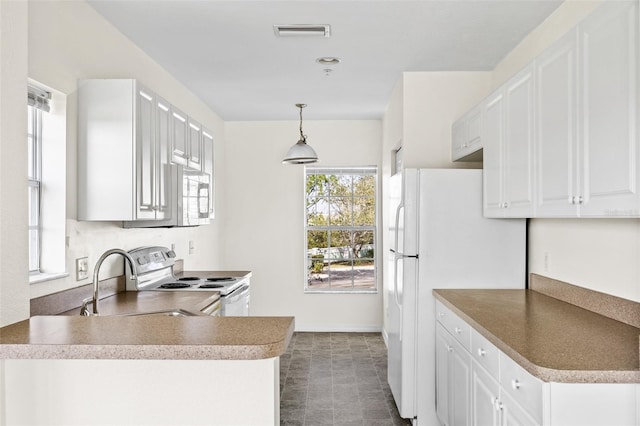 kitchen featuring pendant lighting, white appliances, white cabinetry, dark tile floors, and sink