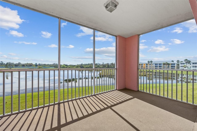 unfurnished sunroom featuring a water view