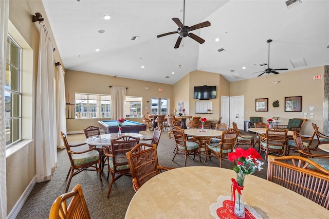 carpeted dining area with high vaulted ceiling and ceiling fan