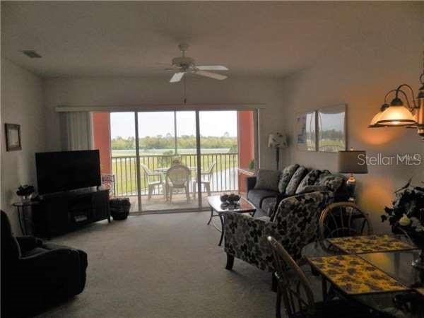 living room with light carpet and ceiling fan