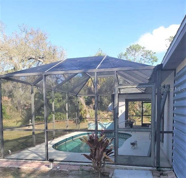 view of pool featuring a patio and glass enclosure