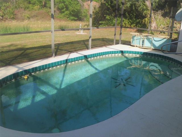 view of swimming pool featuring a lawn