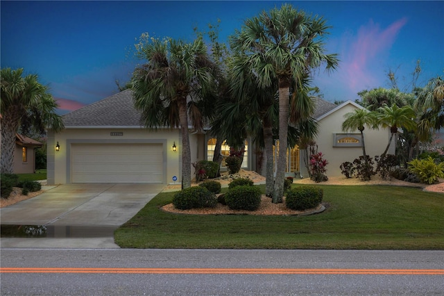 view of front of home with a garage and a yard