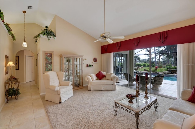 tiled living room featuring ceiling fan and high vaulted ceiling