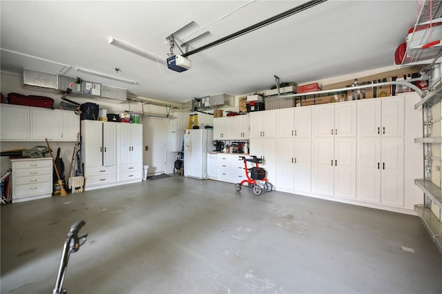 garage featuring white refrigerator with ice dispenser and a garage door opener