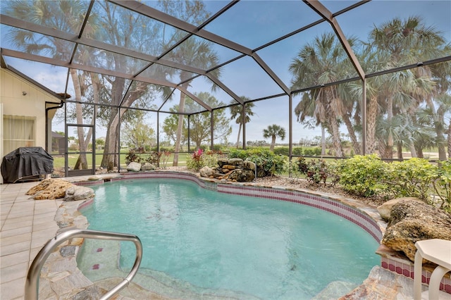 view of swimming pool with glass enclosure, a patio area, and grilling area