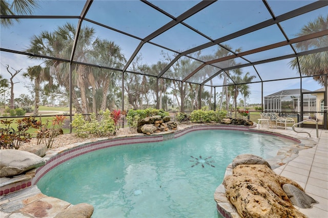 view of swimming pool featuring a patio area and a lanai