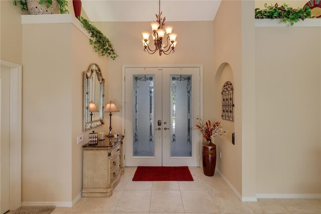 entryway with a chandelier, light tile patterned flooring, and french doors