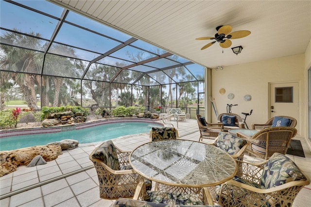 view of swimming pool featuring glass enclosure, ceiling fan, and a patio