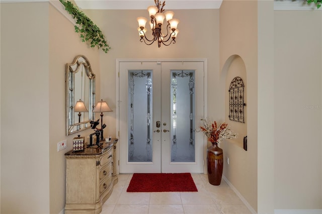 tiled foyer entrance featuring french doors and a notable chandelier