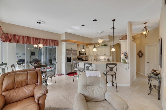 living room with a notable chandelier and light tile patterned flooring