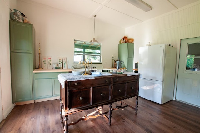 kitchen with white refrigerator, dark hardwood / wood-style flooring, green cabinets, and hanging light fixtures