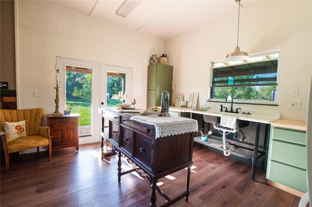 interior space with pendant lighting, dark wood-type flooring, a healthy amount of sunlight, and green cabinets