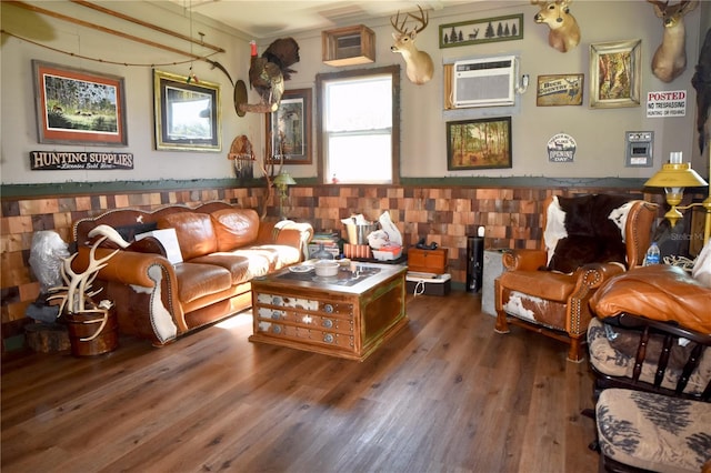 living room with a wall mounted AC and dark wood-type flooring