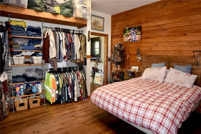 bedroom with wood-type flooring and wooden walls