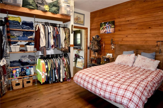 bedroom featuring hardwood / wood-style flooring and wooden walls