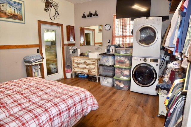 interior space with hardwood / wood-style floors, sink, and stacked washer and clothes dryer