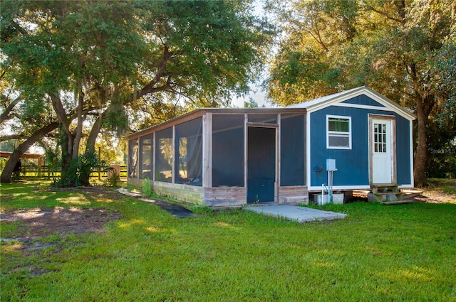 back of property featuring a lawn and a sunroom