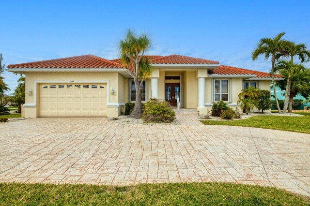 mediterranean / spanish-style home featuring a garage and french doors