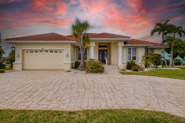 mediterranean / spanish-style house featuring french doors and a garage