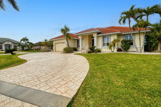 mediterranean / spanish house featuring a front yard and a garage