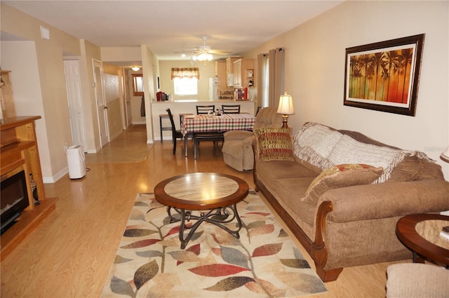 living room featuring ceiling fan and light wood-type flooring