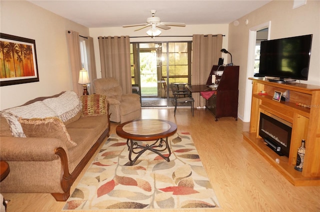 living room with light hardwood / wood-style floors and ceiling fan