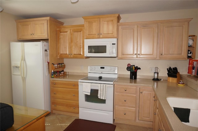 kitchen featuring light tile floors, light brown cabinets, white appliances, and sink