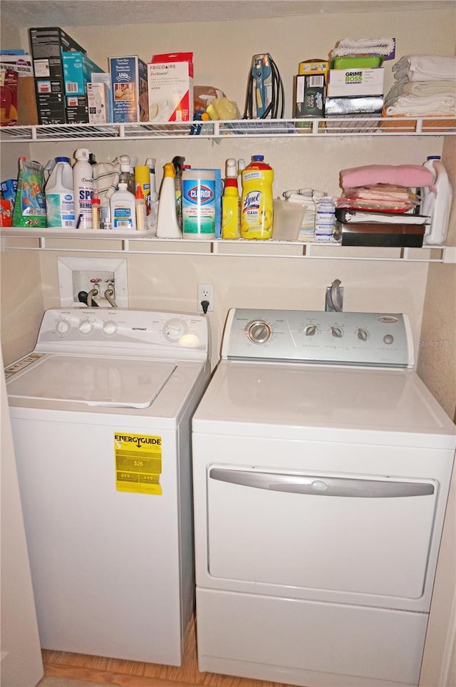 washroom featuring washer hookup, light hardwood / wood-style floors, electric dryer hookup, and washing machine and dryer