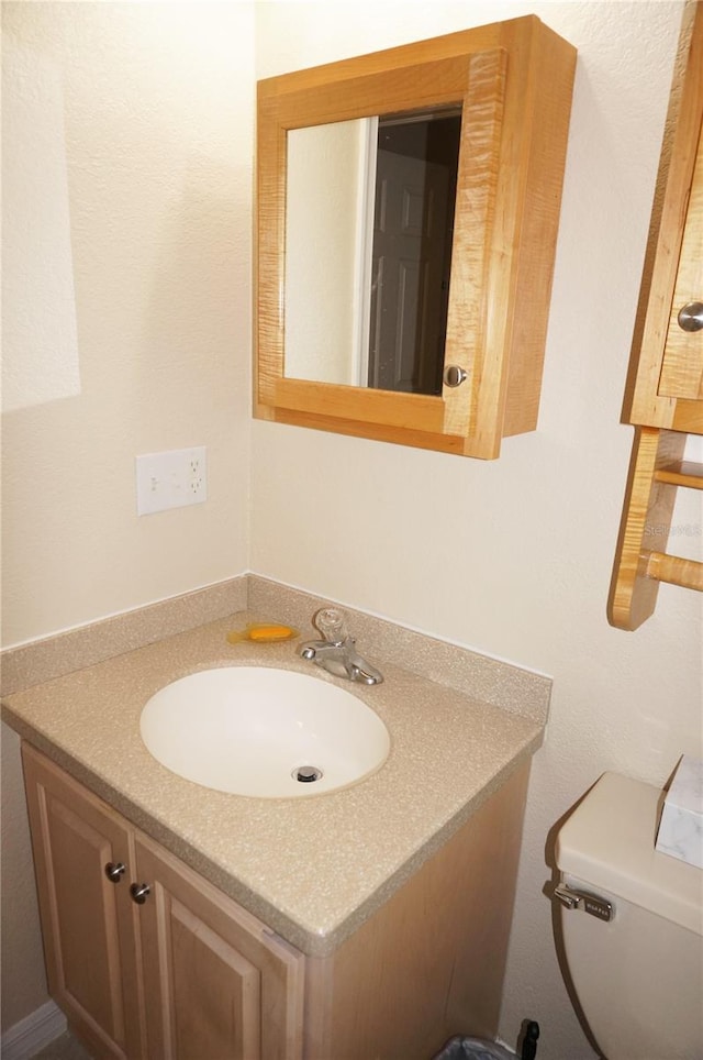 bathroom with large vanity and toilet